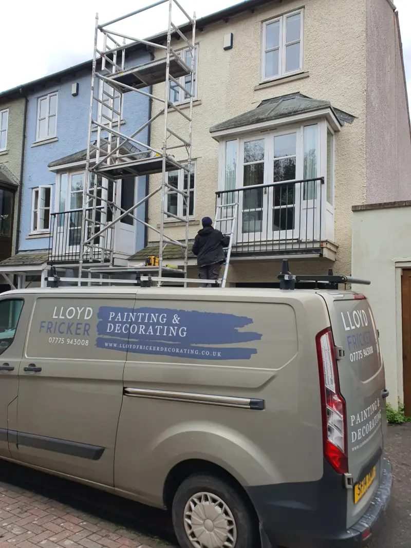 Lloyd Fricker working on exterior painting and decorating in Stroud with scaffolding and van in foreground.